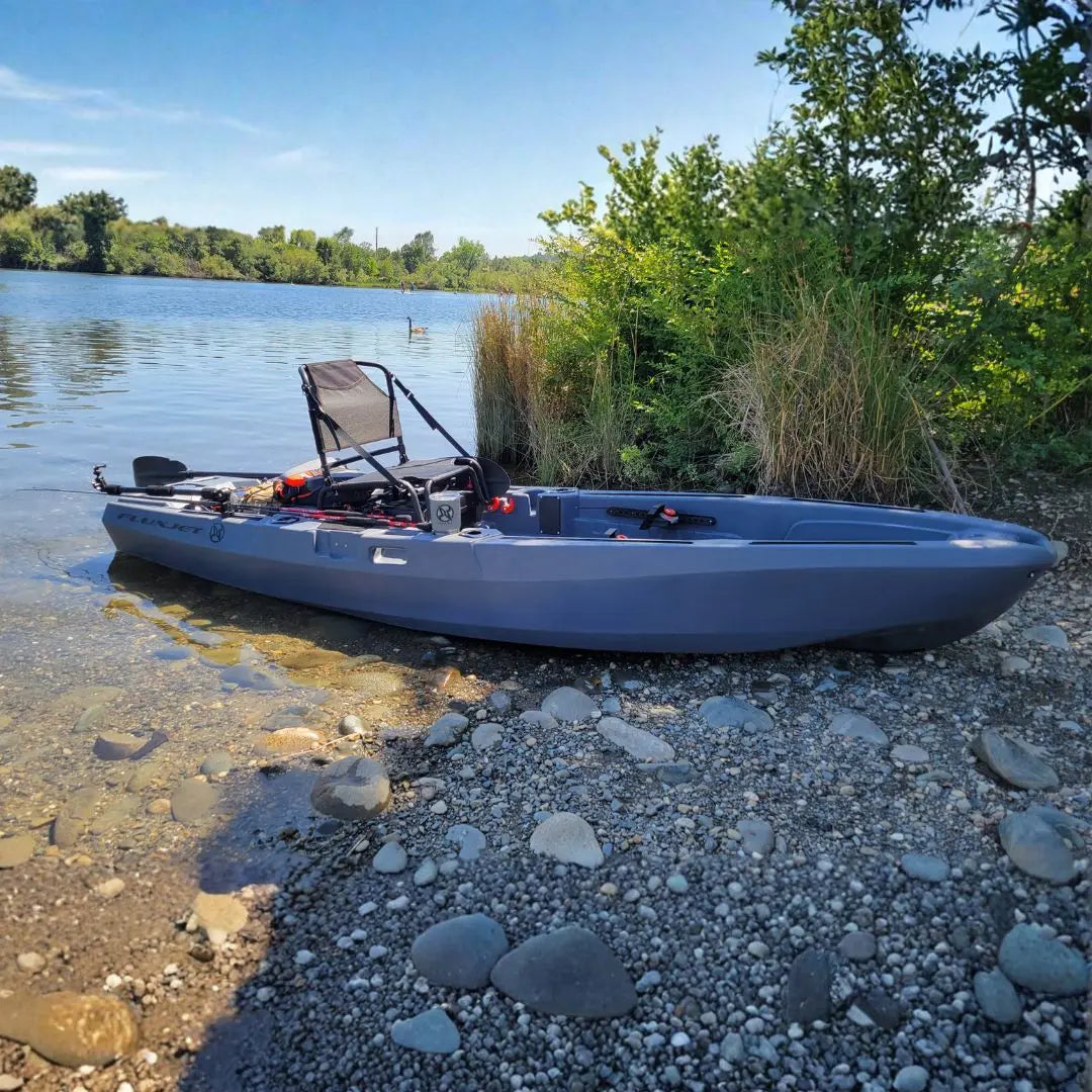 Blue kayak on a rocky shore with water and trees in the background