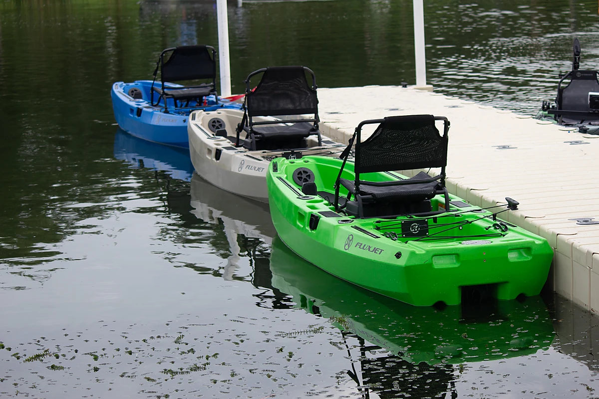 FluxJet kayaks in several colors lined up at a dock
