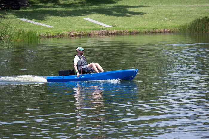 Blue FluxJet electric jet fishing kayak making a high-speed pass across open water