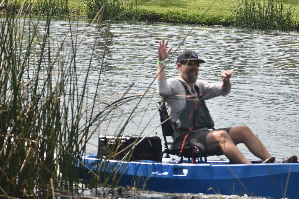 Blue FluxJet kayak moving through shallow reeds