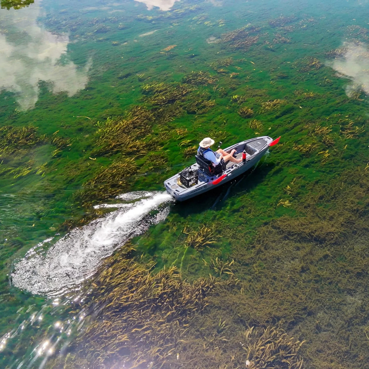 Aerial view of a gray FluxJet electric kayak running over shallow weed beds