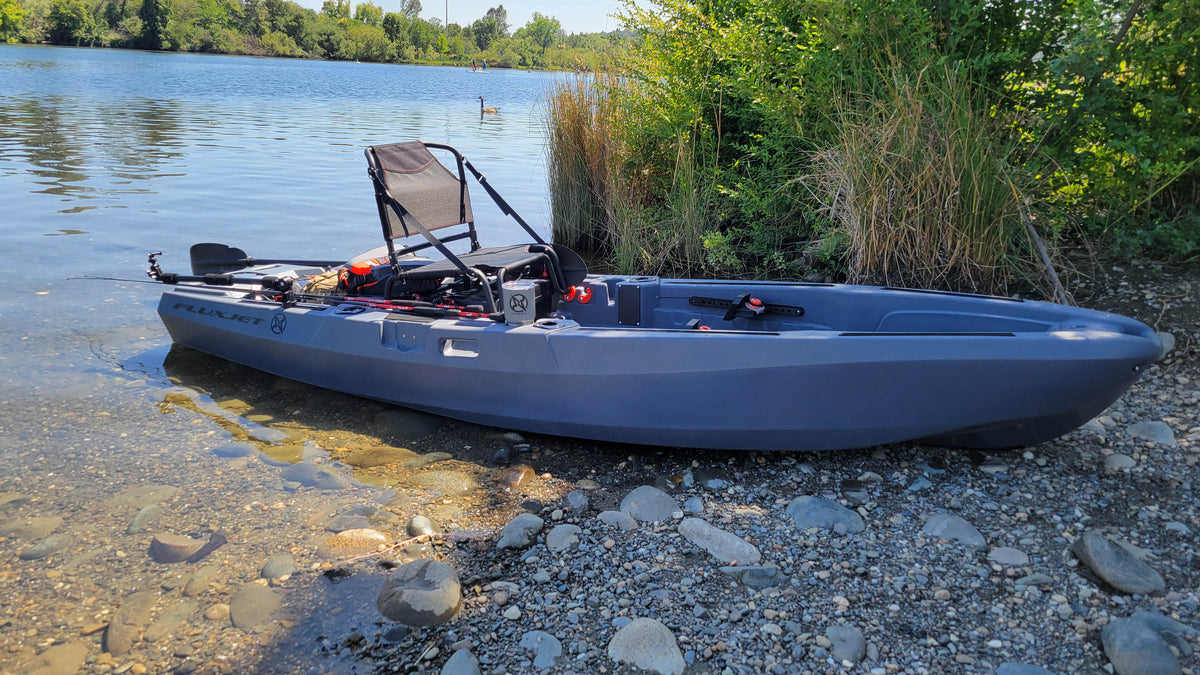 FluxJet electric fishing kayak with seat and gear by lake shore