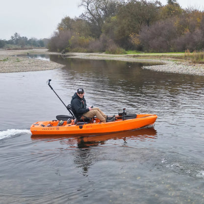 Angler seated on an orange FluxJet electric kayak cruising on a river