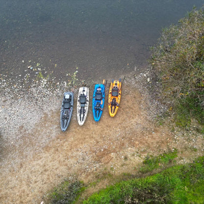  Top-down aerial view of four FluxJet kayaks lined up side by side on a rocky riverbank next to shallow water.