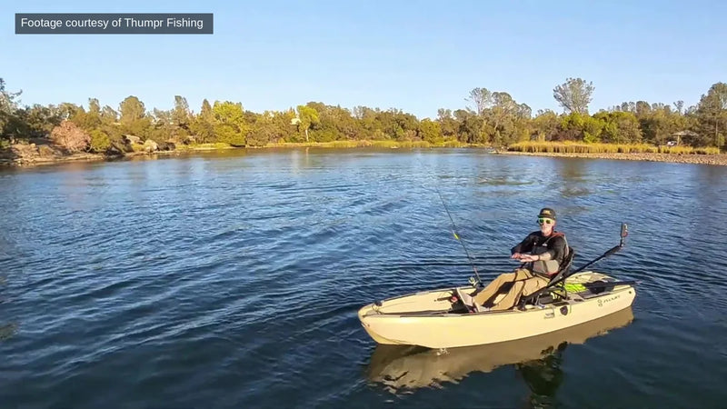 Angler fishing hands-free from a tan FluxJet kayak on a sunny lake